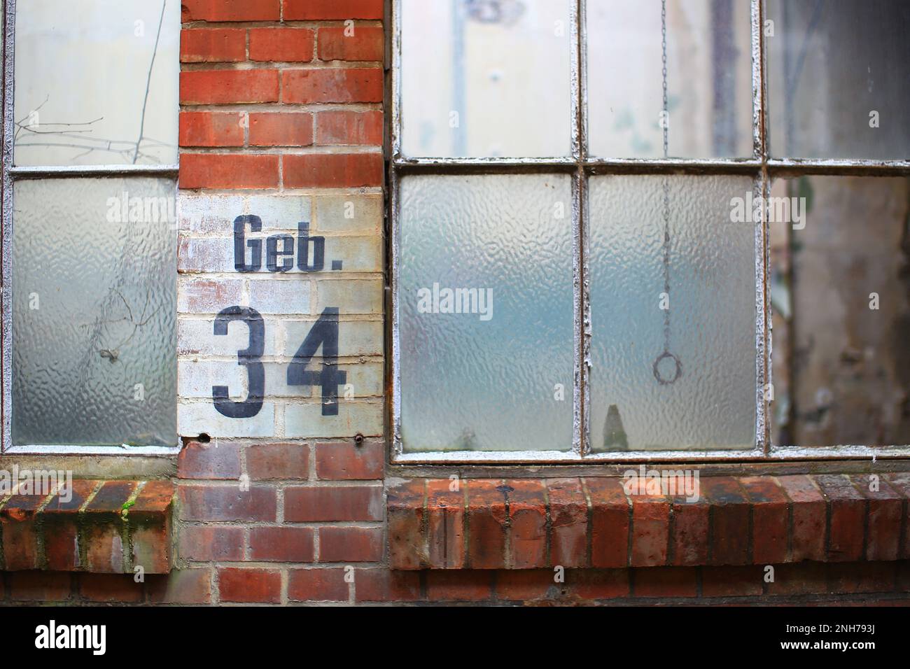 Old factory windows with the German inscription Geb. 34 (building 34). Stock Photo