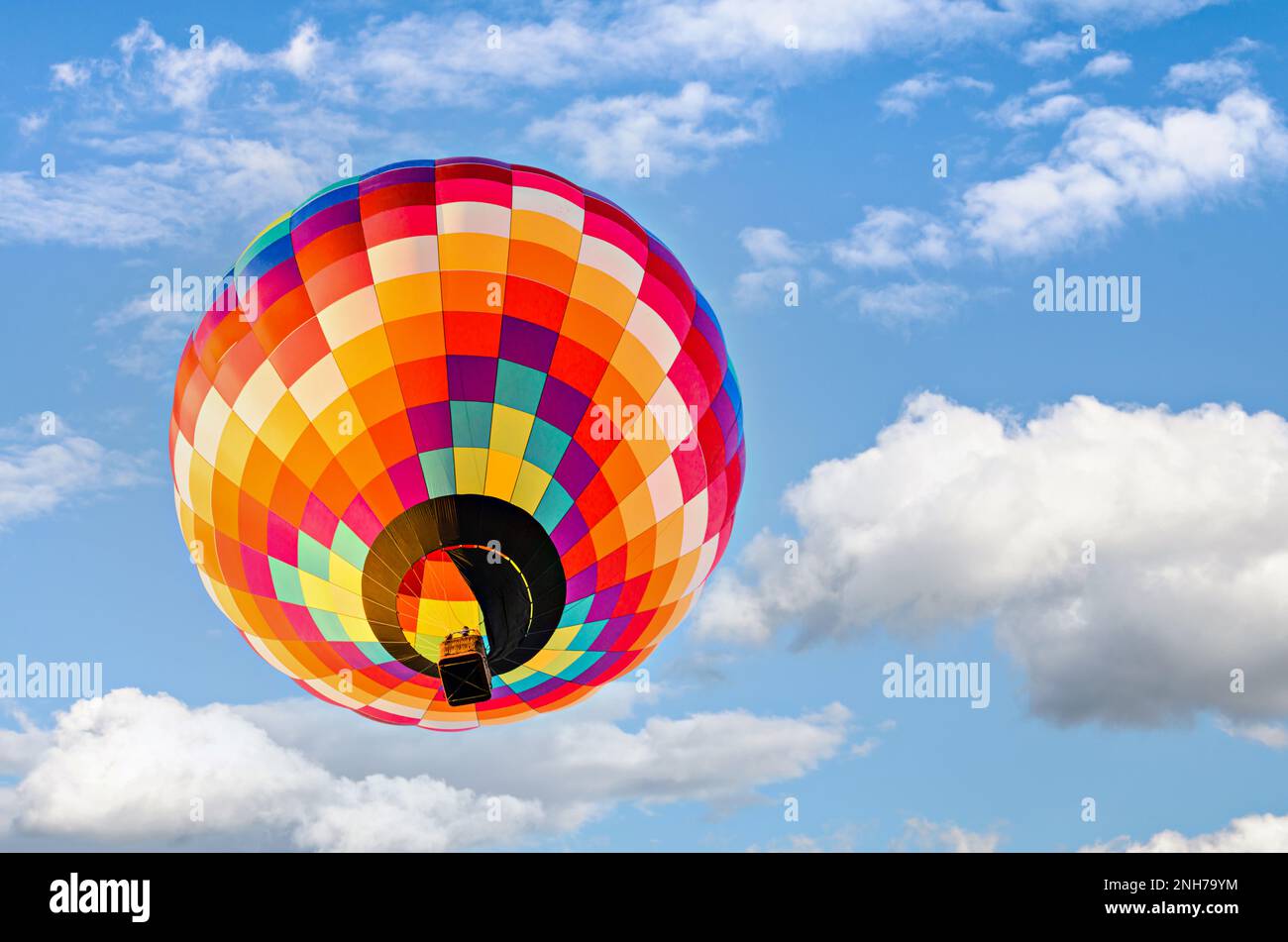 Colorful hot air balloon flying over blue sky with white clouds Stock ...