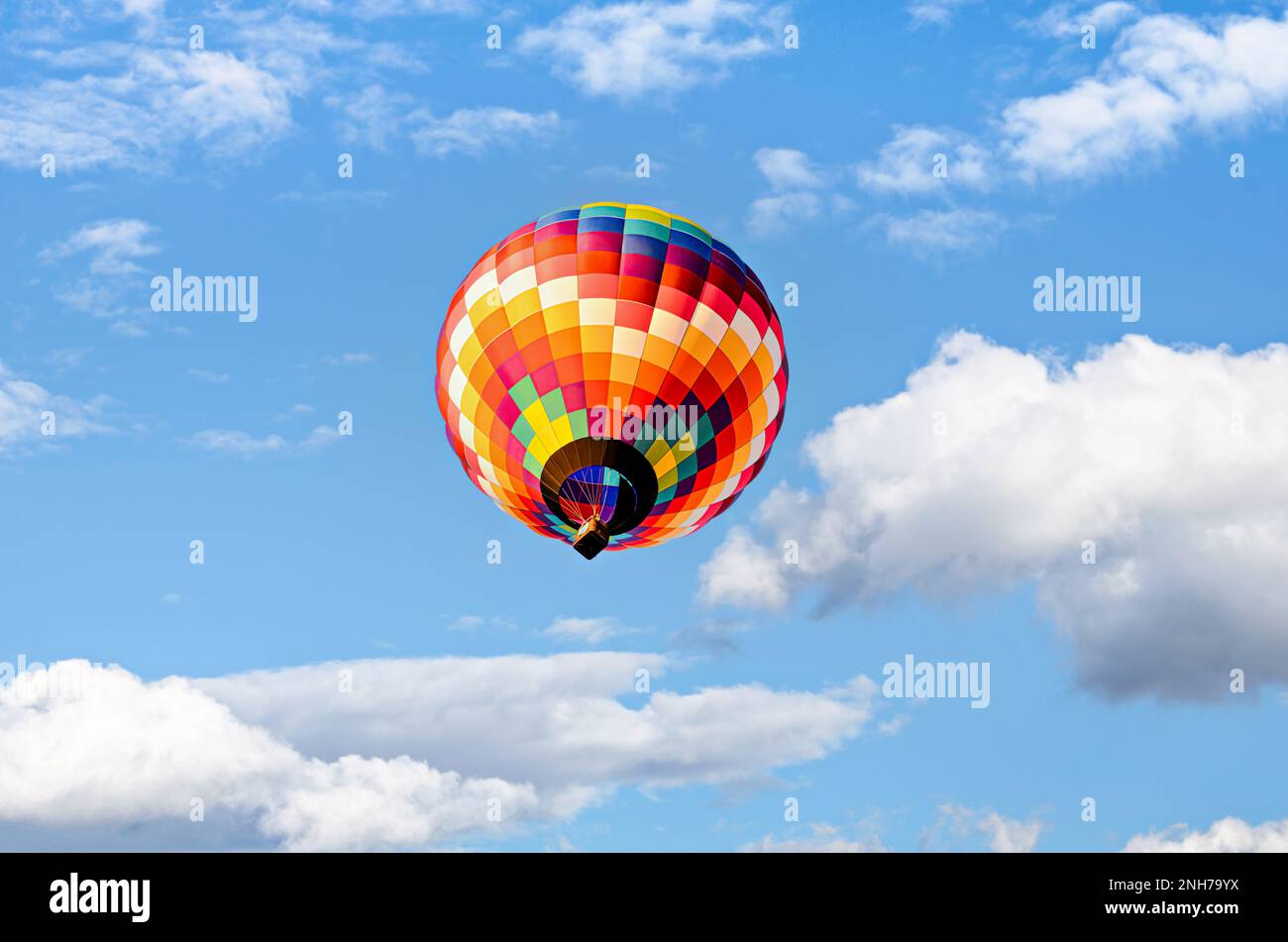 Colorful hot air balloon flying over blue sky with white clouds Stock ...