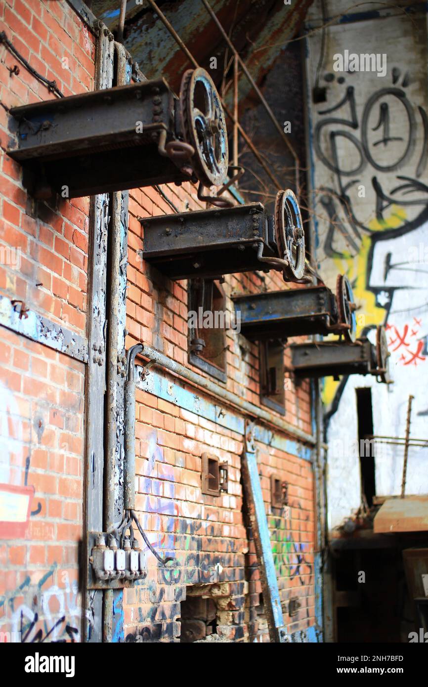Disused coal furnace with rusty wheels for fuel supply. Stock Photo