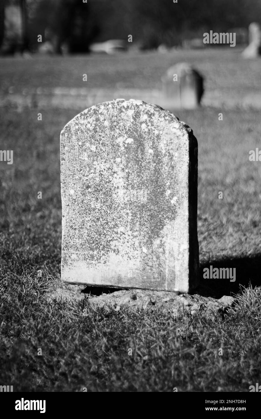 Typical common worn and weathered limestone tombstone with a blank