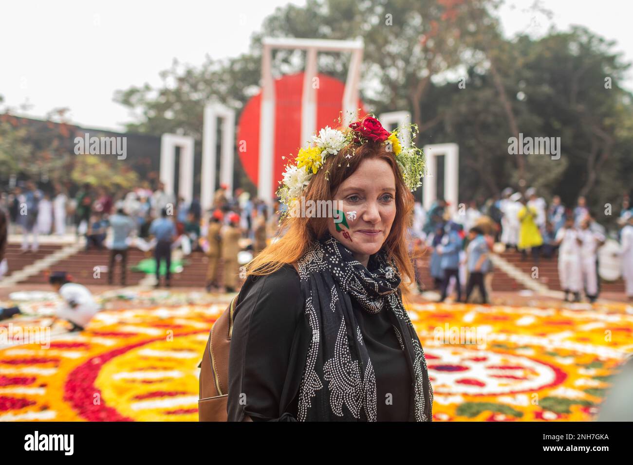 A foreigner poses for a photo with flowers on her head at the Martyr's Monument, or Shaheed Minar during the International Mother Language Day in Dhaka. Bangladeshis pay tribute at the Martyr's Monument, or Shaheed Minar, on International Mother Language Day in Dhaka, International Mother Language Day is observed in commemoration of the movement where a number of students died in 1952, defending the recognition of Bangla as a state language of the former East Pakistan, now Bangladesh. (Photo by Sazzad Hossain/SOPA Images/Sipa USA) Stock Photo