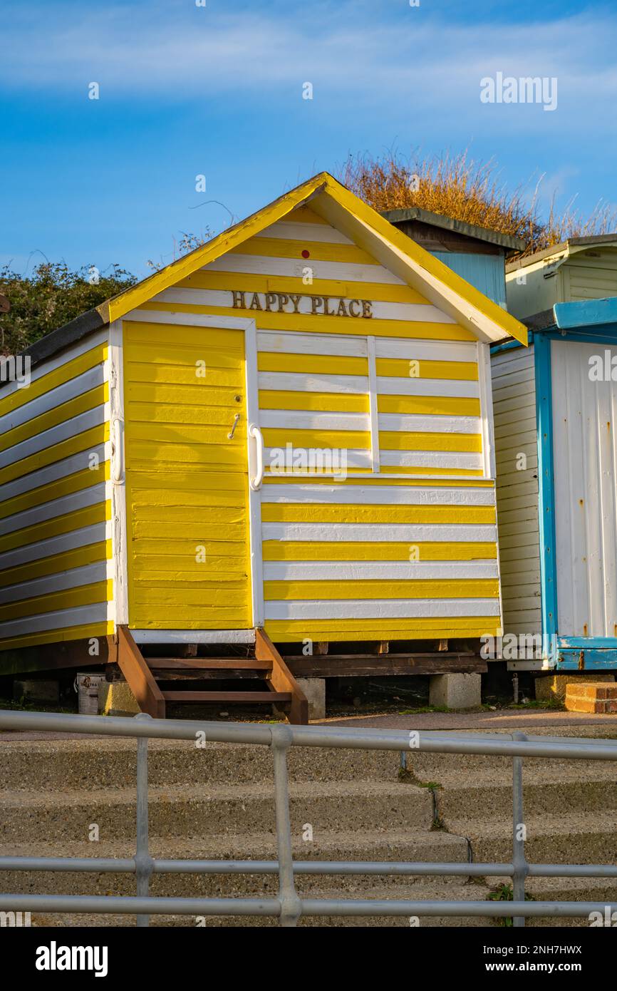 Yellow striped beach hut on the beach at Walton on the Naze Essex Stock Photo