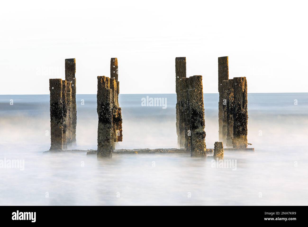 Weatherworn posts, industrial relics from the old seawater extraction pipelines that fed the Steetley Magnesia Works prior to the construction of Stee Stock Photo