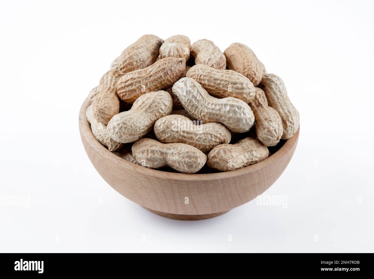 Bowl full of shelled peanuts on white background Stock Photo