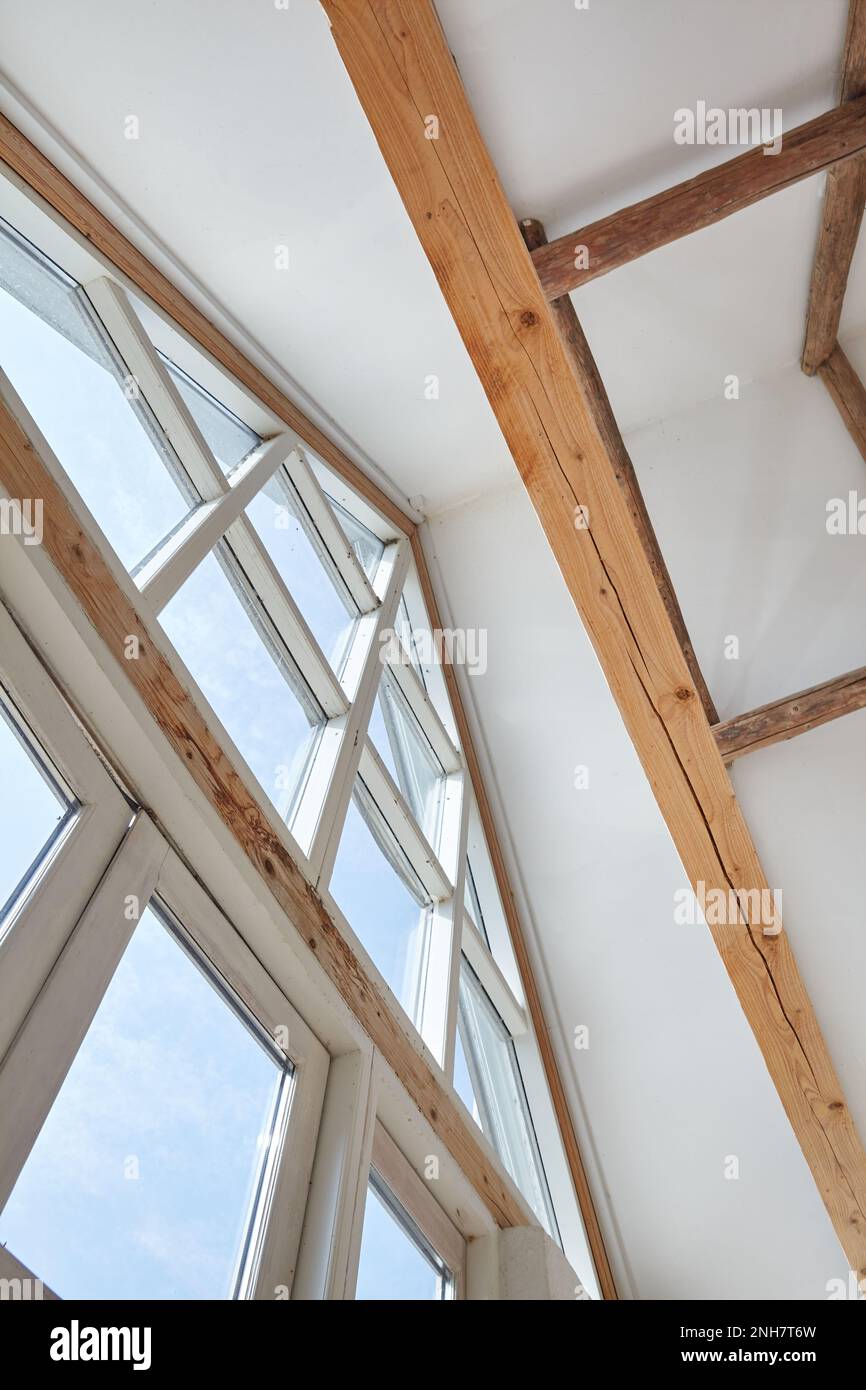 Triangle window going until the frameworks exposed ceiling Stock Photo