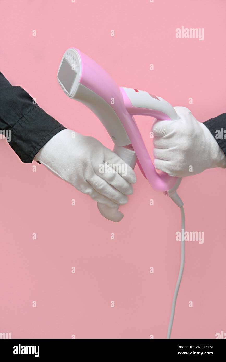 Man holding a disassembled clothes steamer with a plastic water