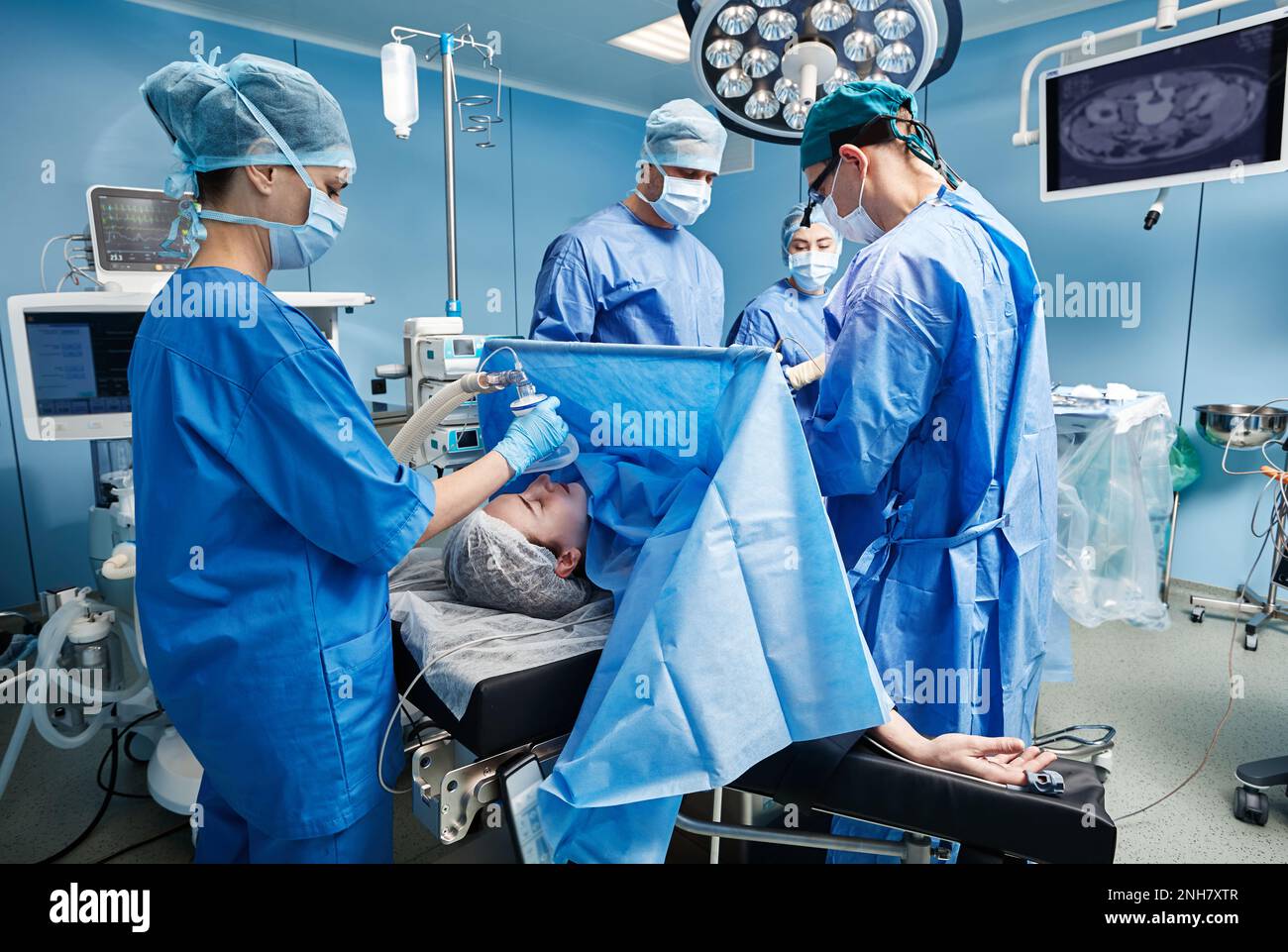 Team of surgeons and nurses performing surgical operation in hospital operating room. Surgery Stock Photo