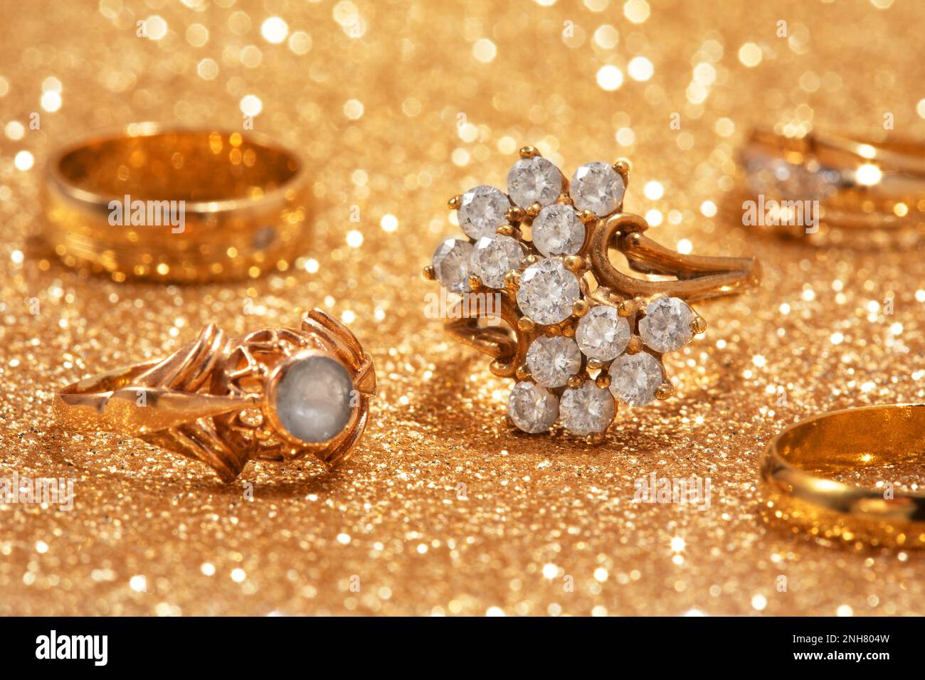 Gold jewelry on a shiny golden background Stock Photo - Alamy, image size:1300x956