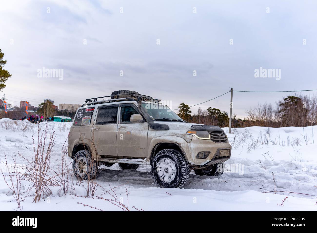 Russian white 4x4 SUV 'UAZ Patriot' rides on a snowy road in winter. Stock Photo