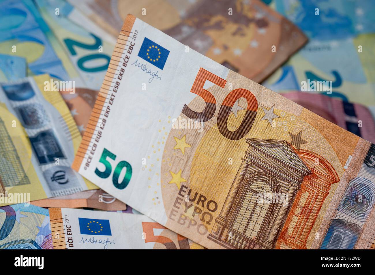 A pile of banknotes on the table. Fifty euro paper money denomination in focus. Mixed euro banknotes in the background. Stock Photo