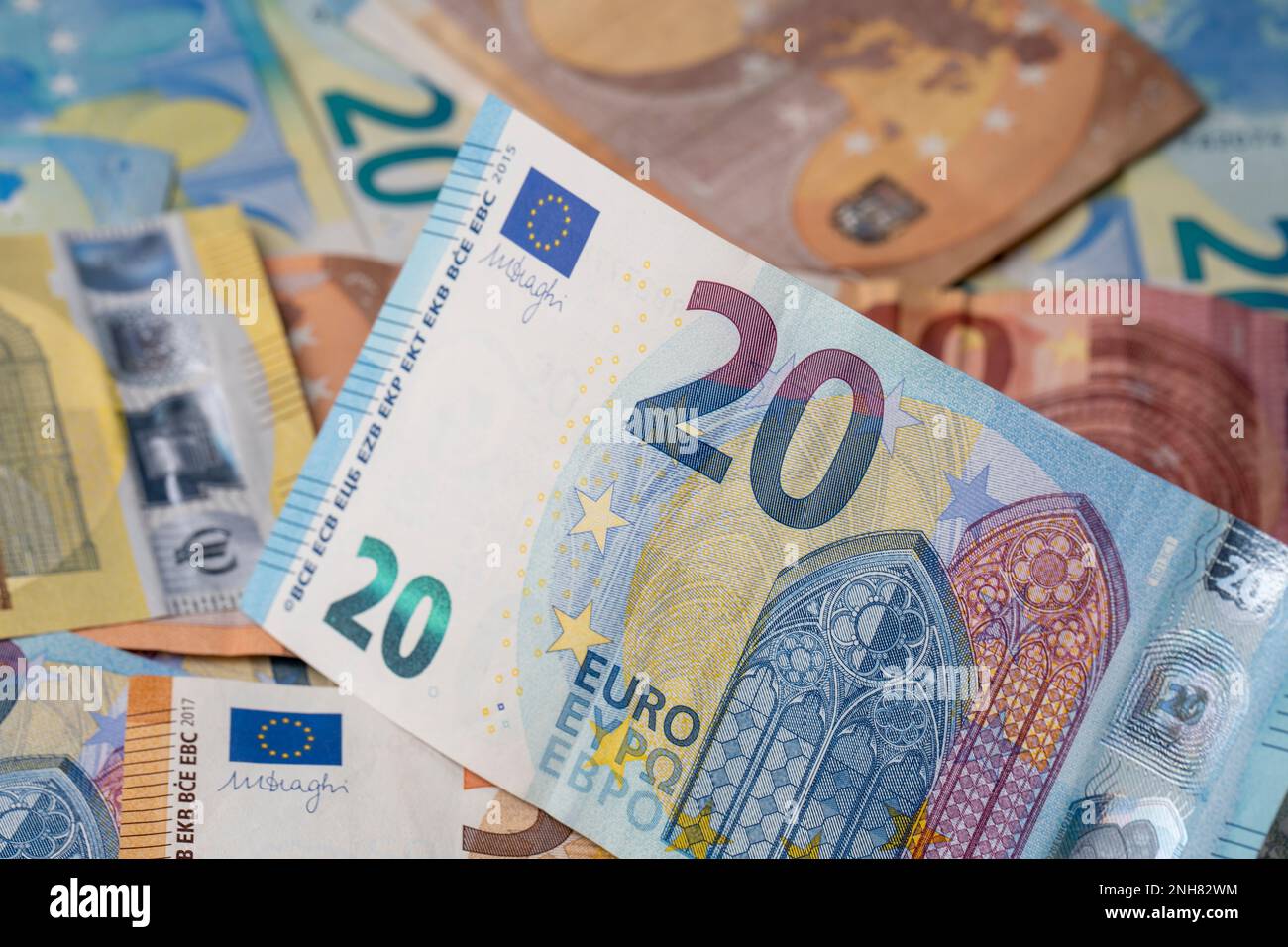 A pile of banknotes on the table. Twenty euro paper money denomination in focus. Mixed euro banknotes in the background. Stock Photo