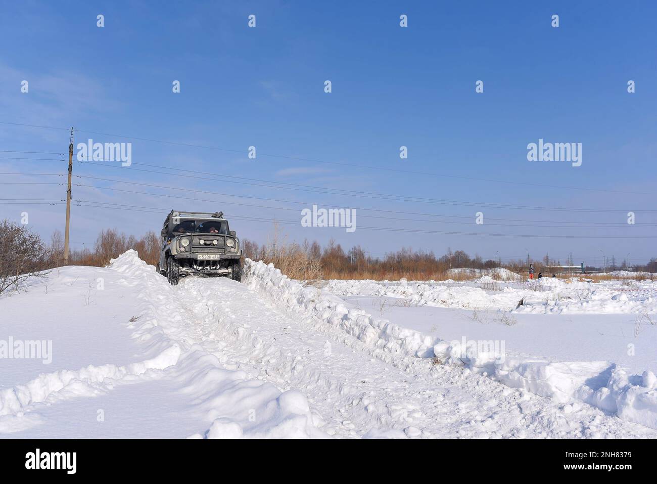 Russian offroad SUV 'UAZ hunter 469' 4x4 rides on a snowy mountain in winter in a field on a bad road. Stock Photo