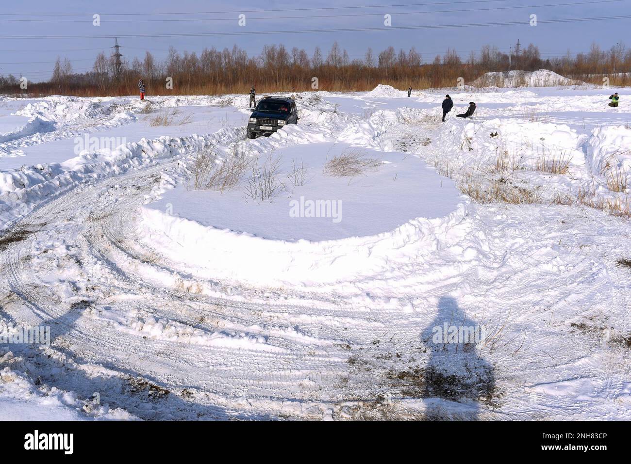 Offroad SUV 'Jeep Grand Cherokee' 4x4 black color goes on a sharp turn on the winter road in the snow. Stock Photo