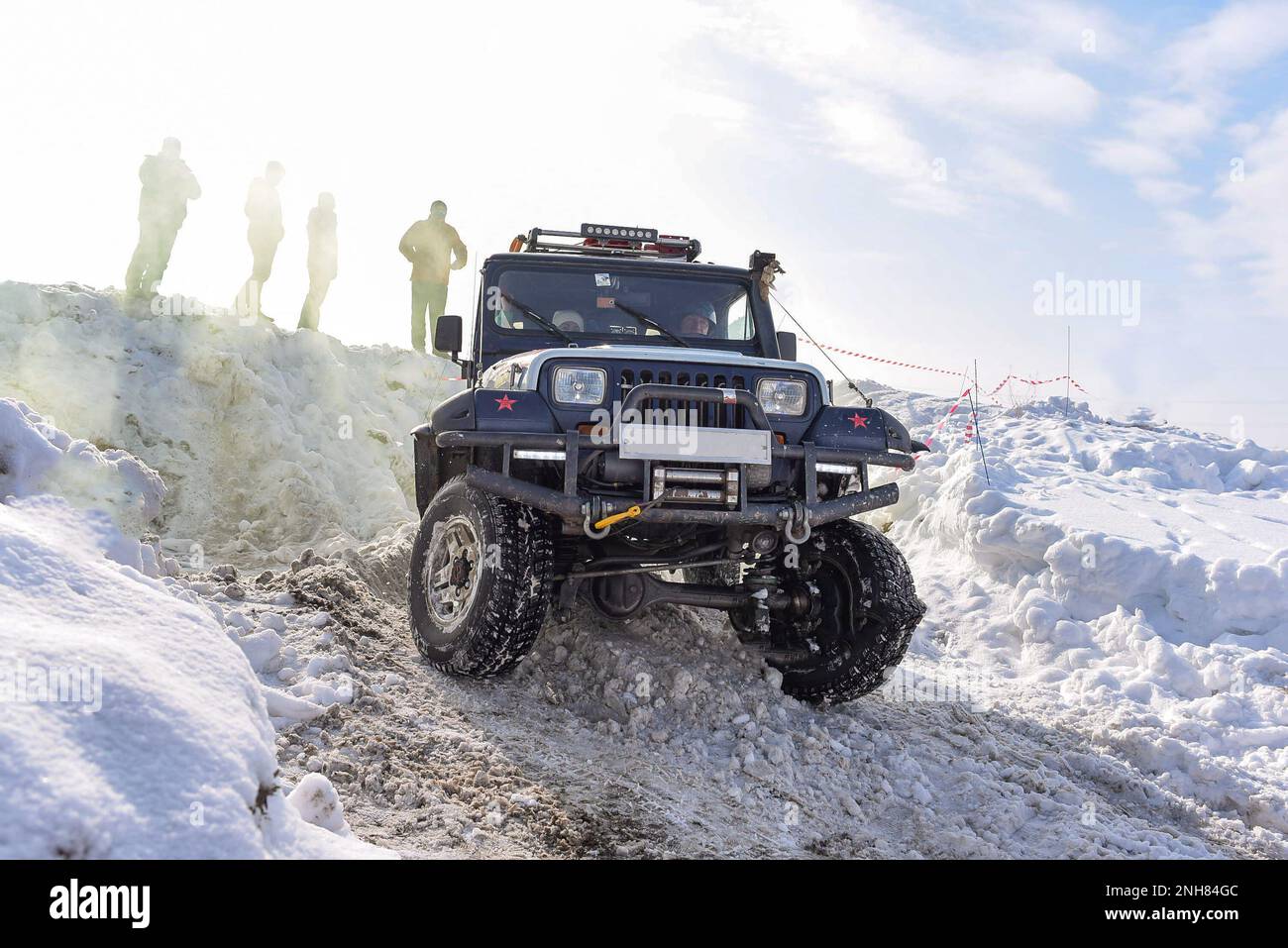 An old SUV Jeep Wrangler drives fast in the snow on a corner at a competition in Russia in Siberia. Stock Photo
