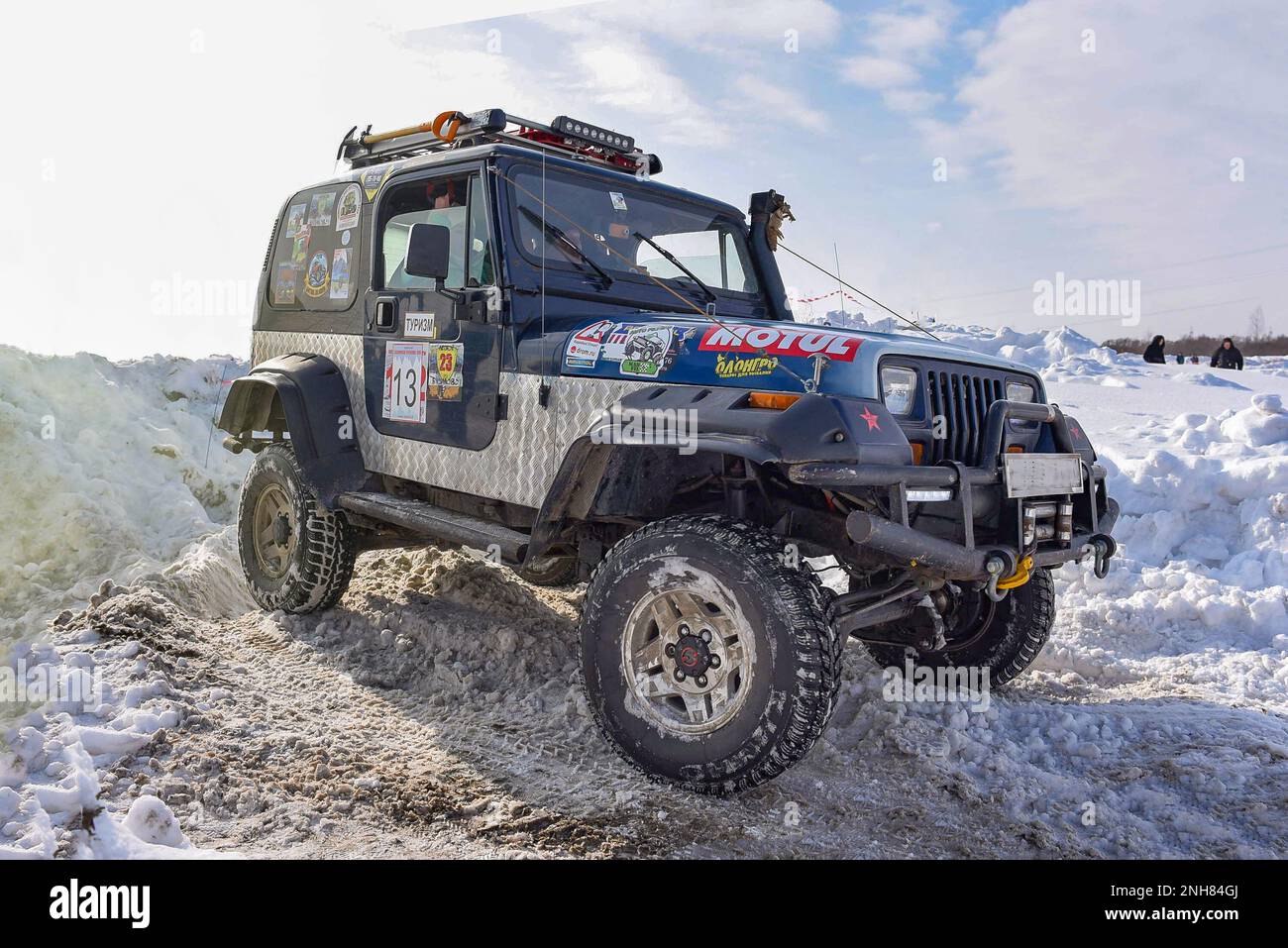 An old SUV Jeep Wrangler drives fast in the snow on a corner at a competition in Russia in Siberia. Stock Photo