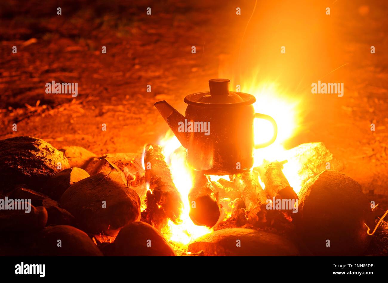 Iron kettle in a flame of fire by night Stock Photo Alamy