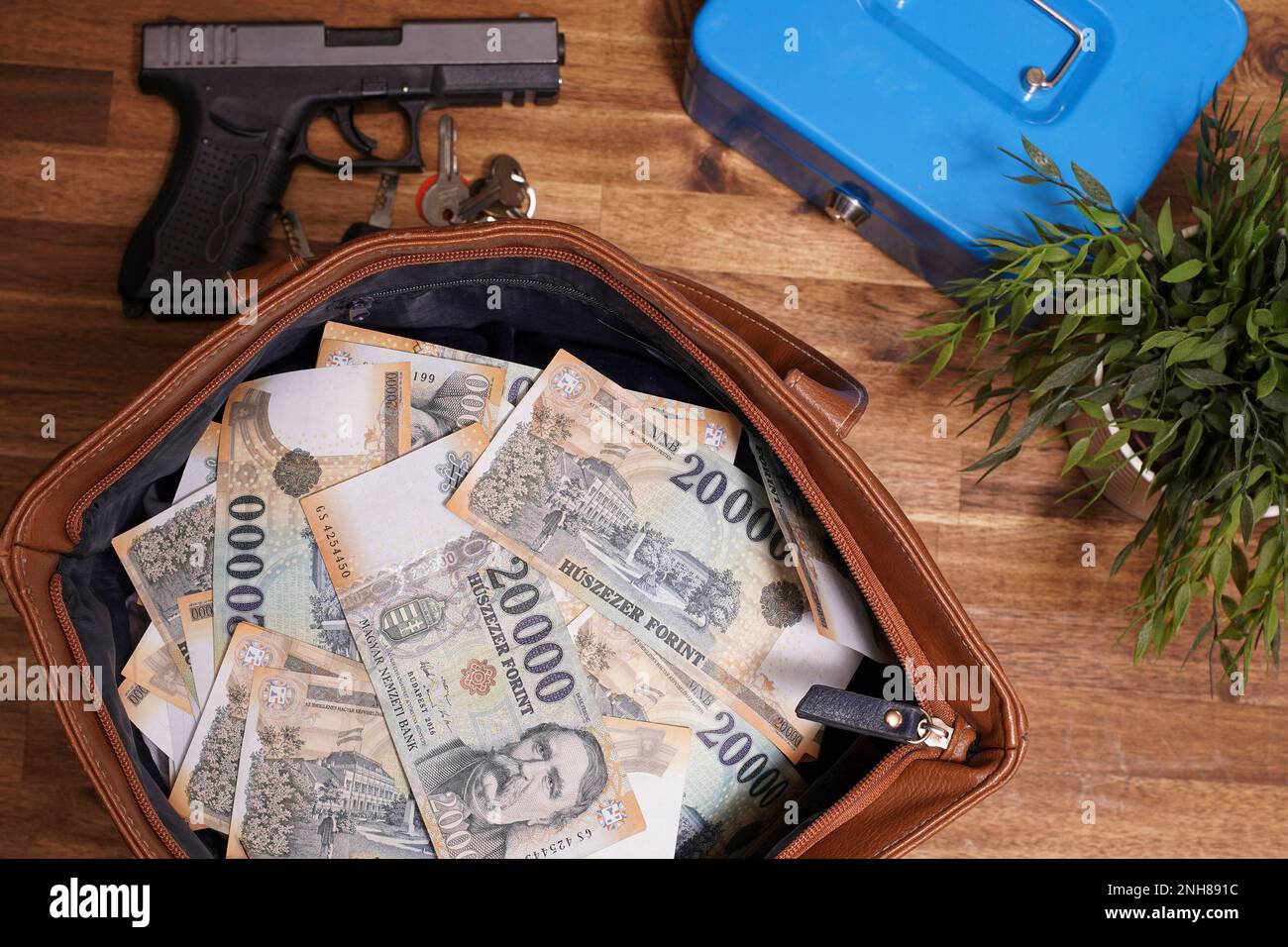 Travel bag with lots of money and gun. On the table is a safe, key and