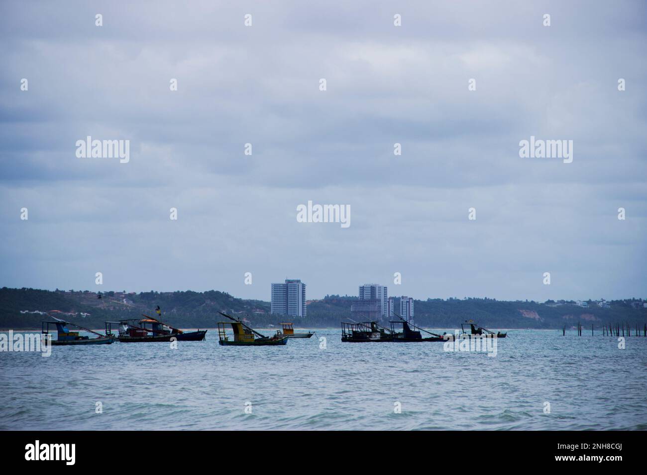 A sunny cloudy day on the beach, with the boats resting in silence. Stock Photo
