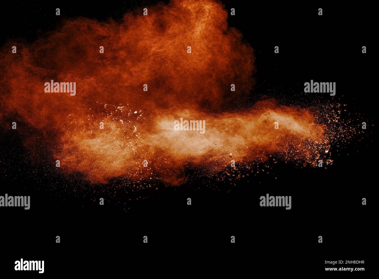 Brown dust explosion cloud.Brown particles splatter on black background. Stock Photo