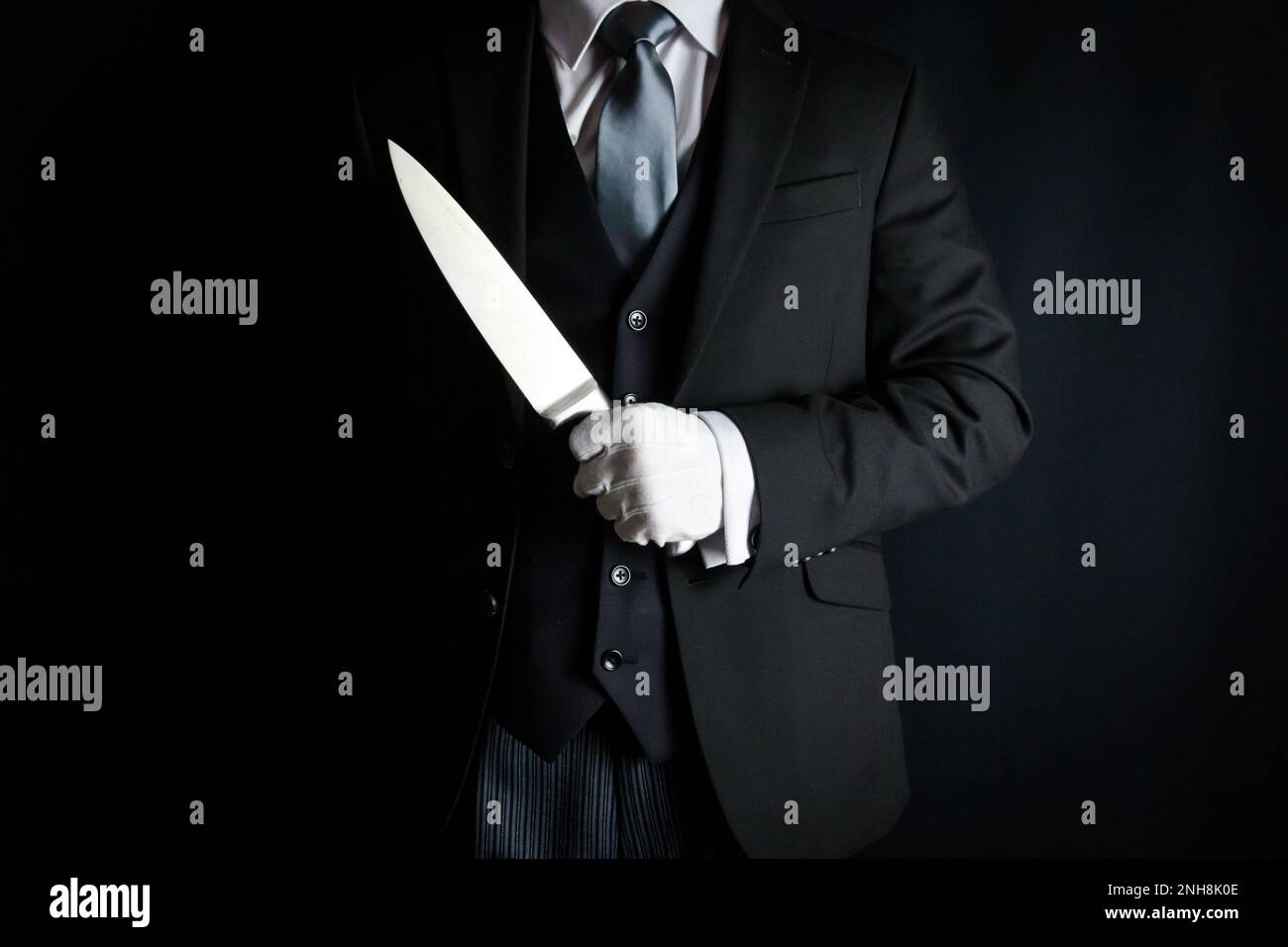 Portrait of Butler in Dark Suit and White Gloves Holding Sharp Knife. Concept of The Butler Did It. Stock Photo