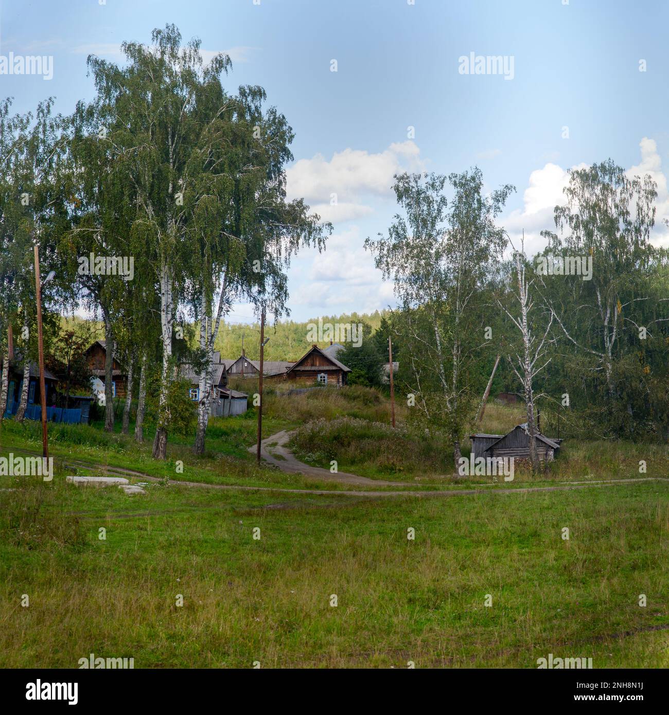 Siberian village landscape with a turn of rural road at the slides with ...