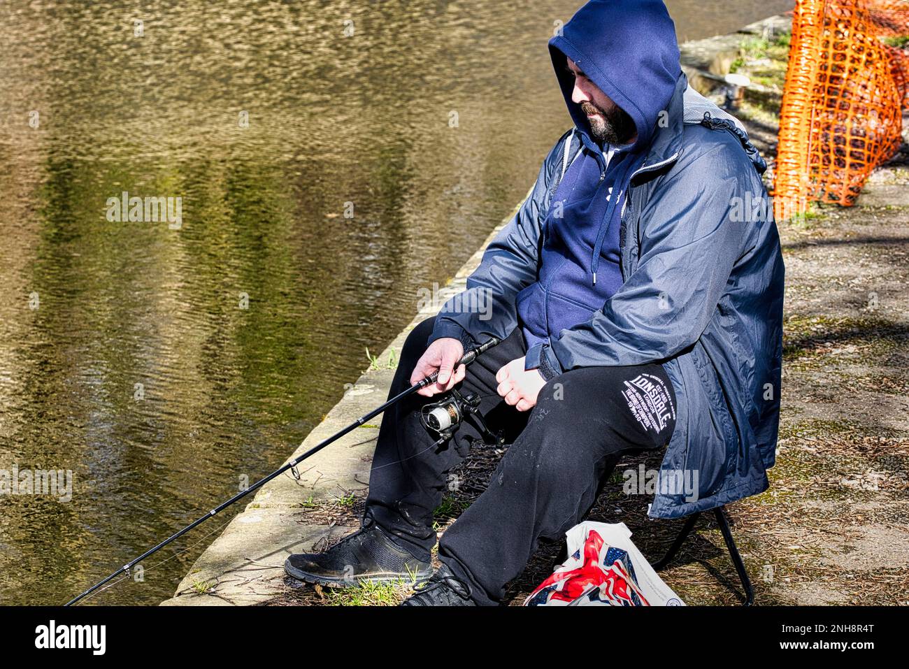 A fisherman fishing from the towpath at Trevor Basin, Llangollen branch of the Shropshire Union canal Stock Photo