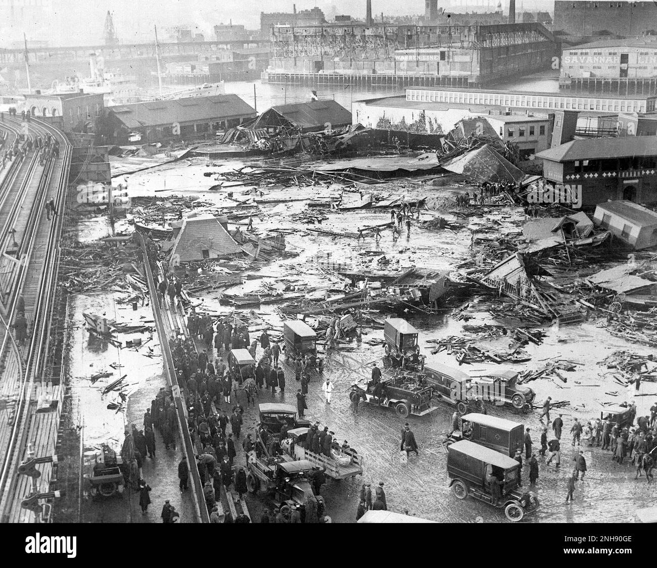 The Great Molasses Flood or the Boston Molasses Disaster, January 15th, 1919. Twenty one people were killed and 150 injured on Commercial Street in Boston's North End when a tank containing 2.3 million gallons of molasses ruptured and exploded. An eight foot wave of liquid moved down Commercial Street at a speed of 35mph. Wreckage of the collapsed tank is visible in background, center, next to a light colored warehouse. Stock Photo