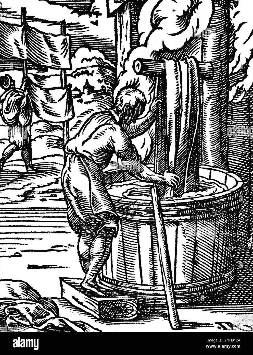 A dyer of cloth is dipping fabric into a large barrel as other sheets are hung up to dry. Woodcut from Jost Amman's Book of Trades, 1568. Stock Photo