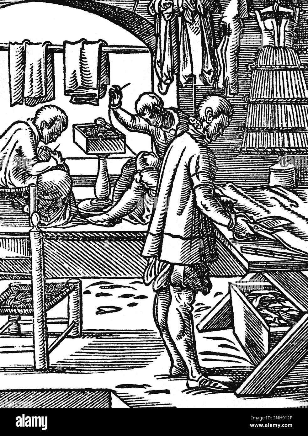 A tailor cutting cloth with scissors while his colleagues sew at a bench. Woodcut from Jost Amman's Book of Trades, 1568. Stock Photo