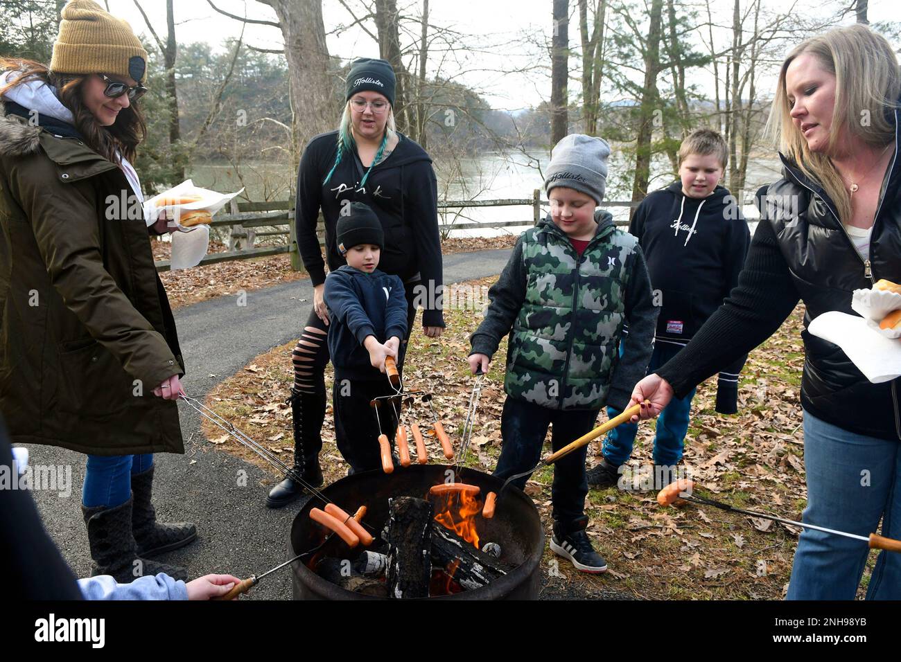 Roasting hot dogs over the open fire pit are, from left, Heather Weikel