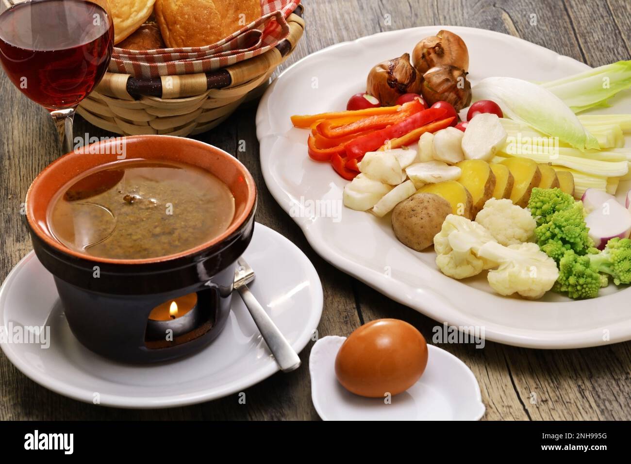 Bagna cauda(Italian Piedmont cuisine)  is a hot dip made from garlic and anchovies.  The dish is served with raw or cooked vegetables. Stock Photo