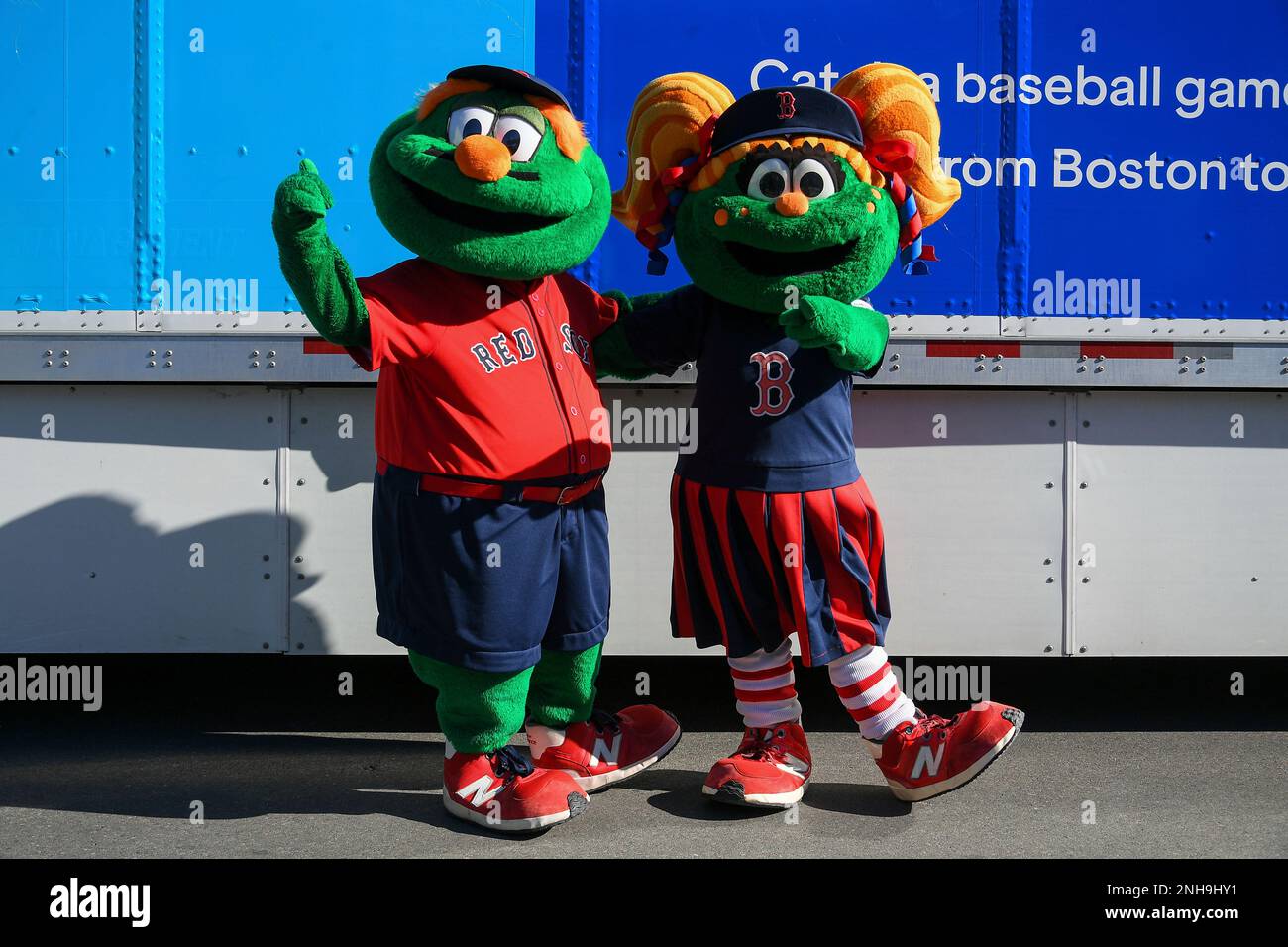 BOSTON, MA - FEBRUARY 03: Boston Red Sox mascots, Wally the Green Monster  (left) and Tessie the Green Monster (right), pose for a photo in front of  the spring training equipment truck