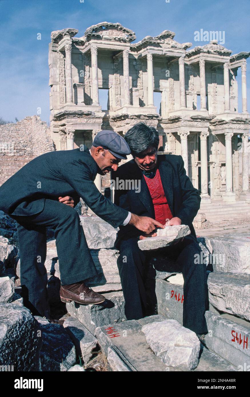 Turkey. Ephesus ruins. Two local male archaeologists studying stone pieces. Stock Photo