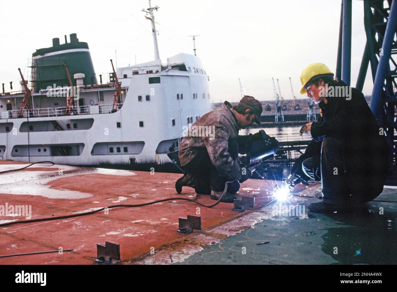 United Kingdom. England. Industry. Ship building. Men welding on ship deck. Stock Photo