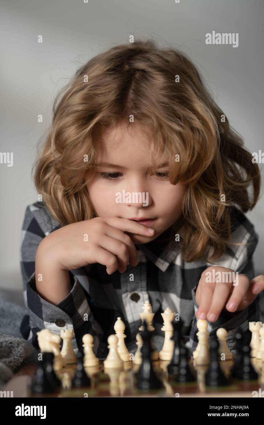 Premium Photo  Young white child playing a game of chess on large chess  board chess board on table in front of school boy thinking of next move