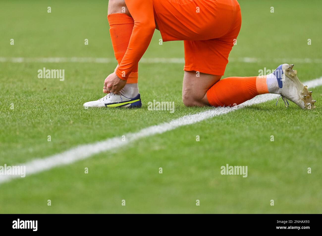The football player itying his shoe on the turf of the pitch Stock Photo