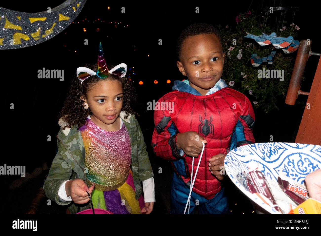 Costumed trick treaters costumed as a unicorn and Spiderman. St Paul Minnesota MN USA Stock Photo