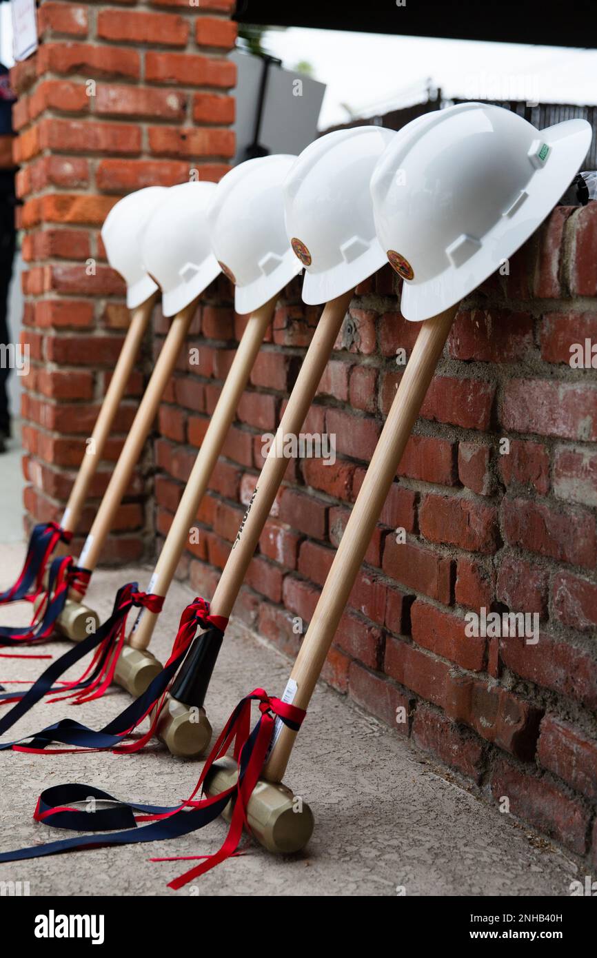 Hard hats and sledge hammers lean against a brick wall at the Fire