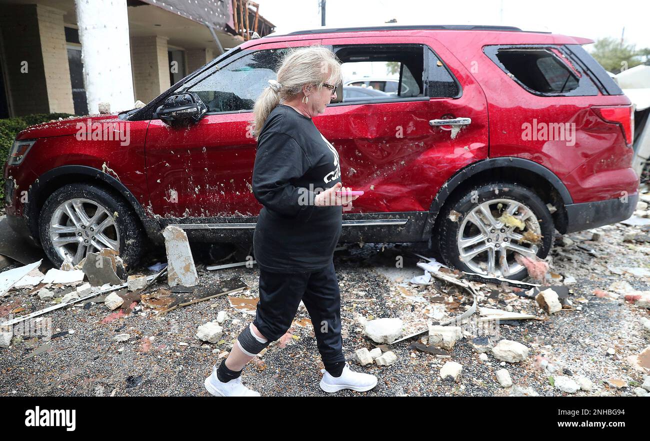 Debbie Allen walks past damaged cars outside her office at La Marquise