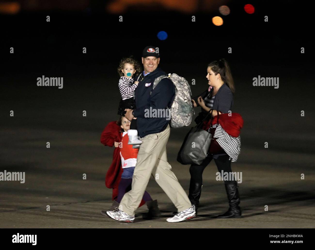 Head coach Jim Harbaugh arrives with daughters Addison, (bottom left