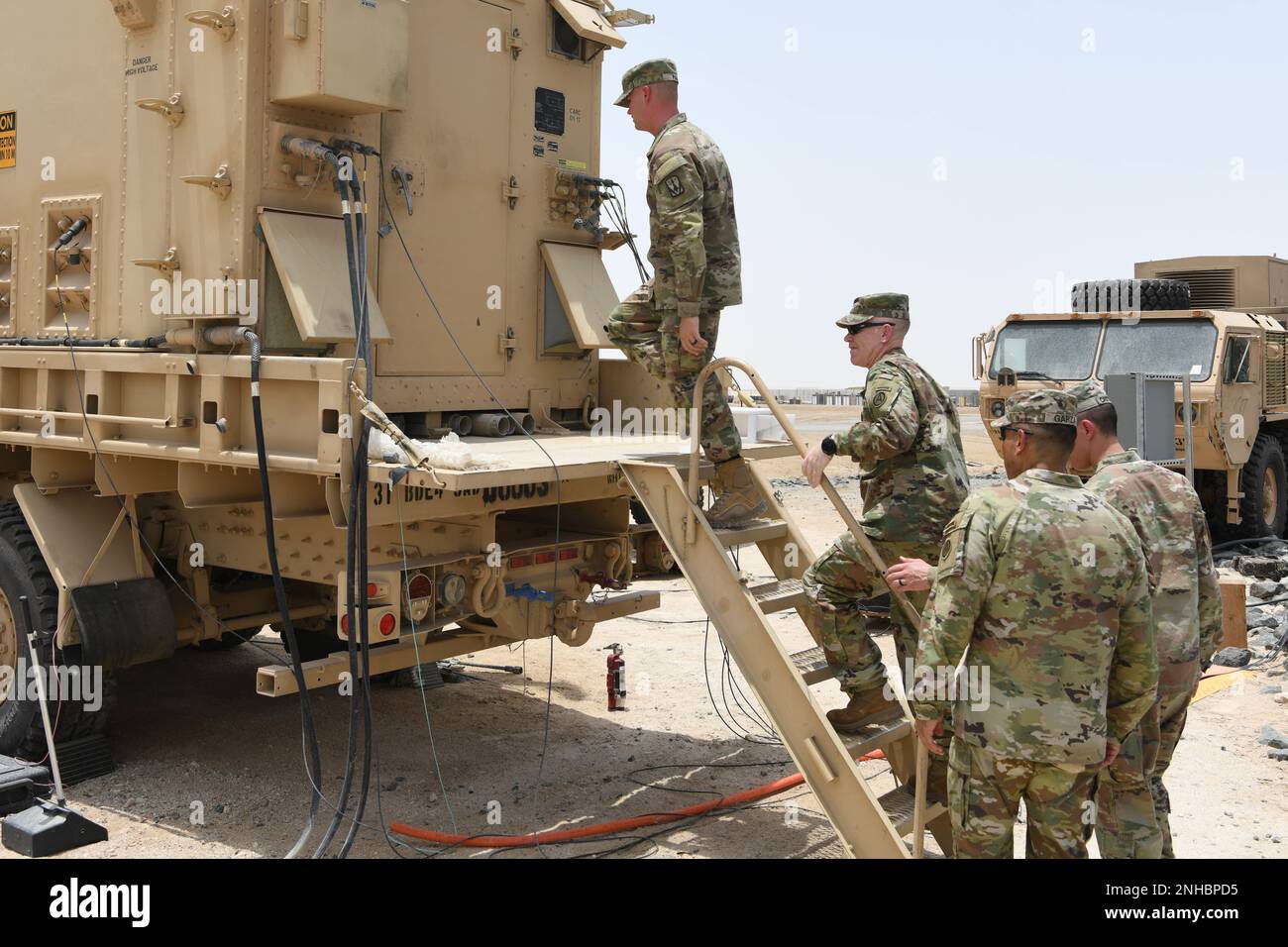 Sgt. Steve Page, a missile and air defense operator assigned to the 4-3 Air Defense Artillery Regiment, guides Lt. Gen. Patrick D. Frank, the commanding general of U.S. Army Central, into an Engagement Control Station July 28, 2022, at Al Dhafra Air Base, United Arab Emirates. The ECS is the unit's primary command and control system, managing radar and launchers on site. Stock Photo