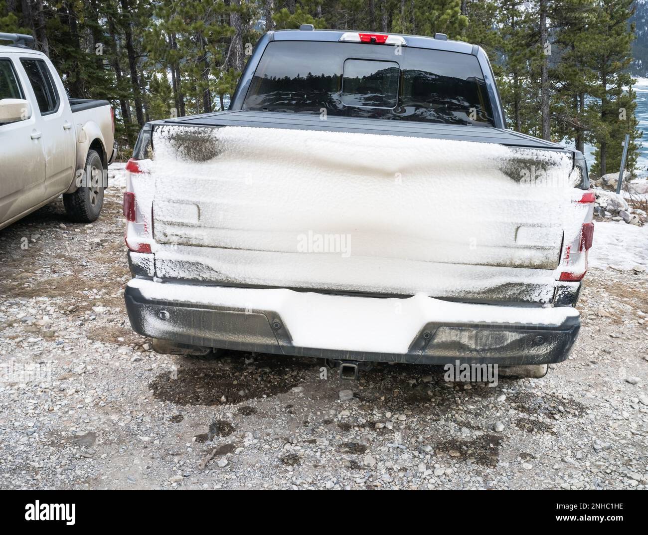 Parked truck with rear covered in snow with limited visibily of lights