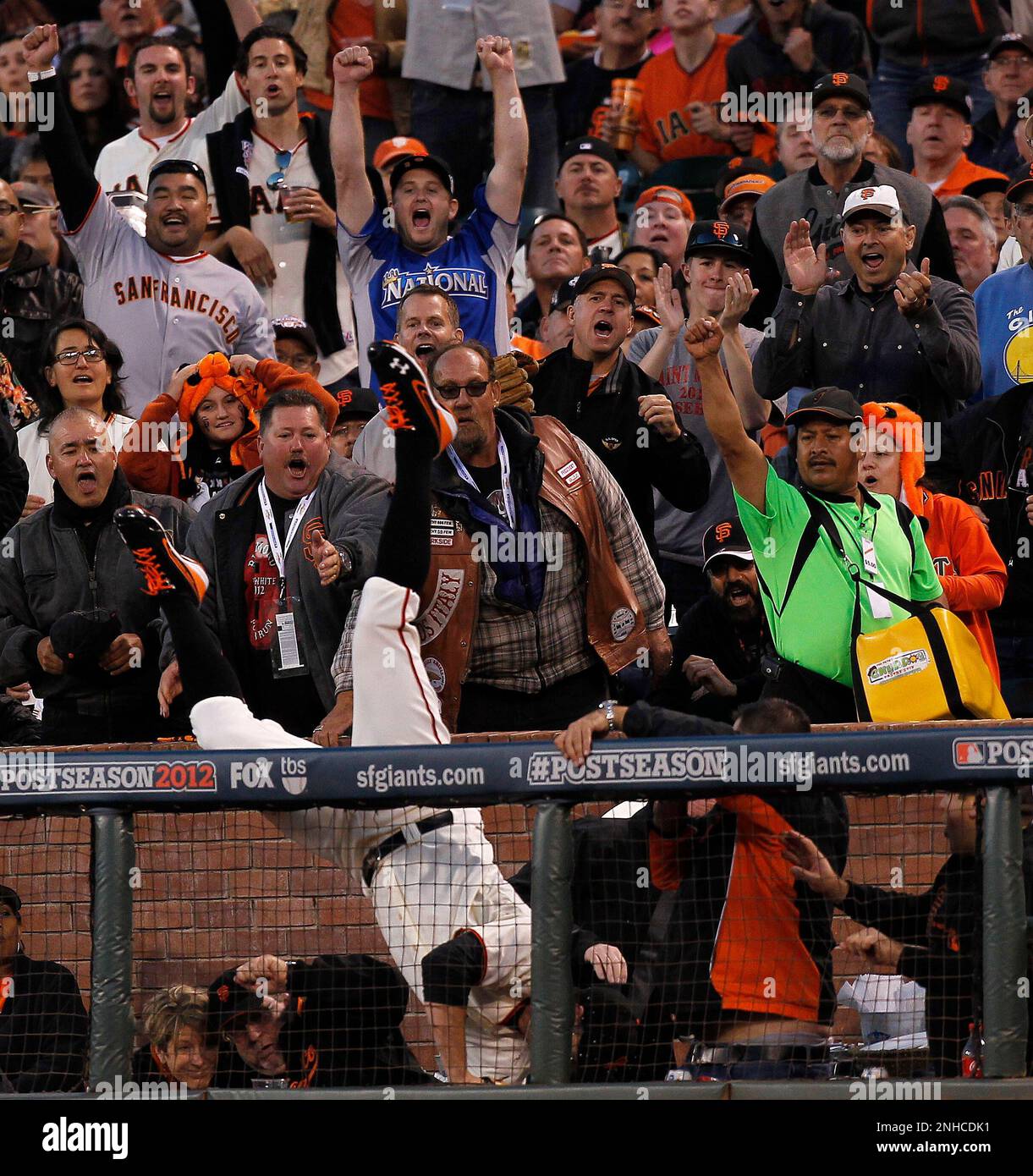 Giants' first baseman Brandon Belt falls over the rail and into