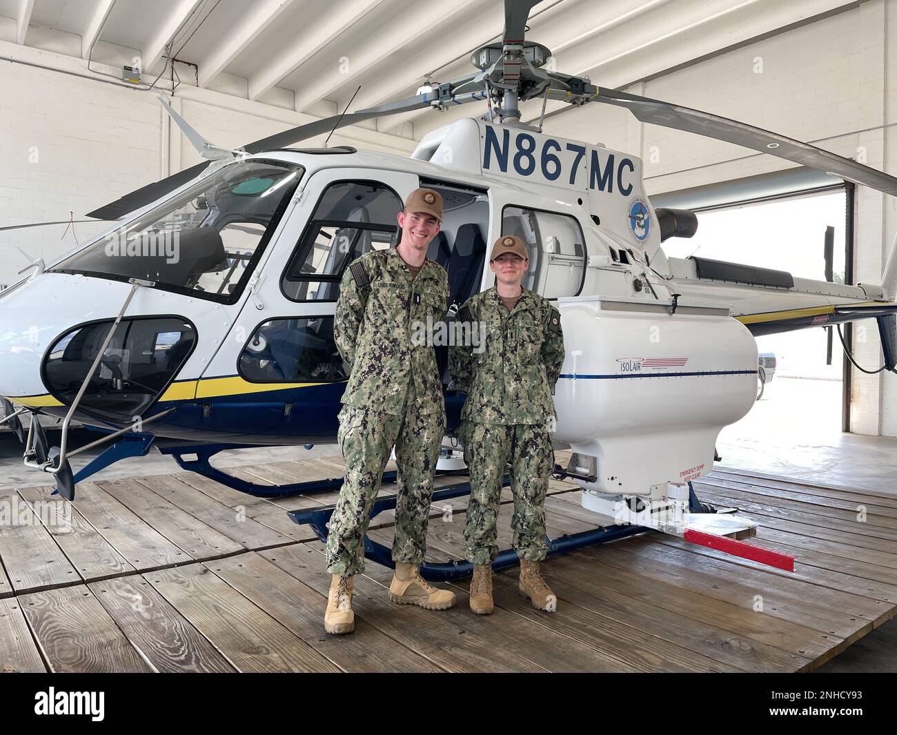 Lee County Mosquito Control District, Lehigh Acres, Fla. (July 28, 2022).  Lt. j.g. Jacob Underwood and Lt. j.g. Sierra Schluep of the Navy Entomology Center of Excellence, in front a helicopter used by Lee County Mosquito Control District for mosquito larval surveillance and treatment. Stock Photo