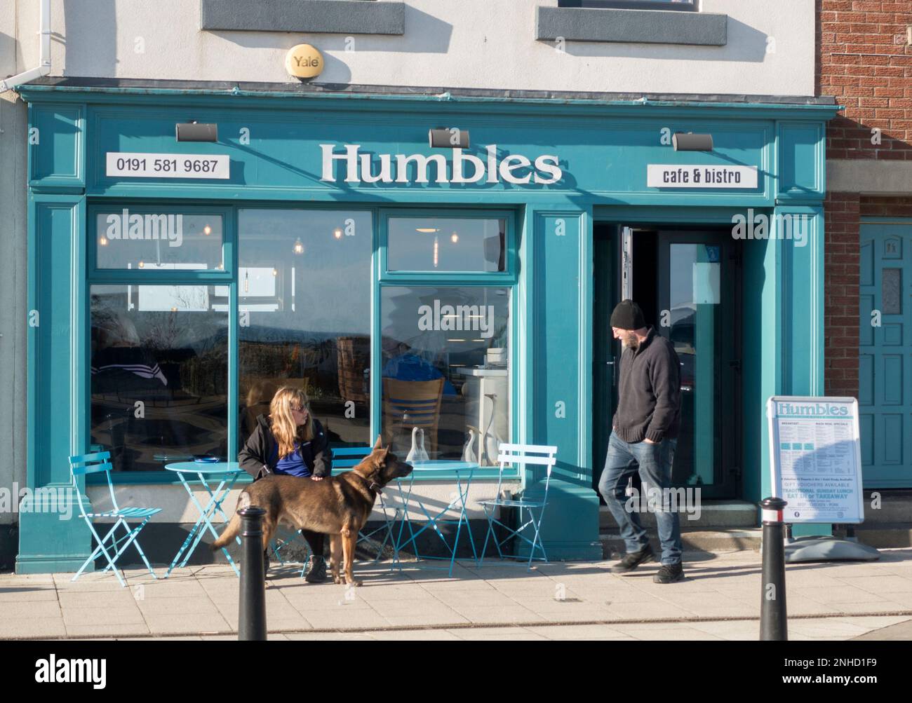 Couple with dog sitting outside Humbles café in Seaham, Co. Durham, England, UK Stock Photo