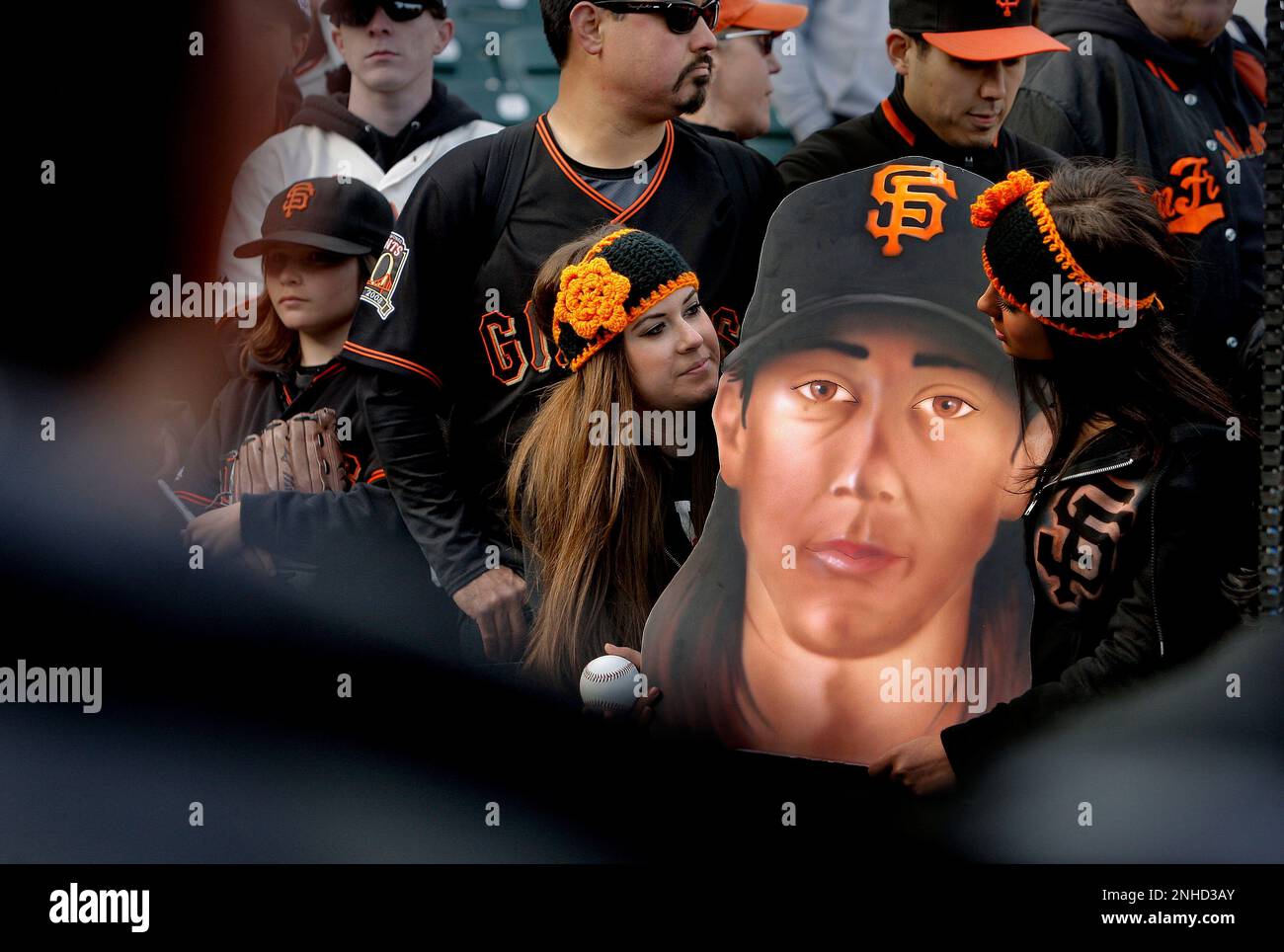 Cousins Michaela and Madisyn Trimble of Visalia hold an airbrushed portrait  of Tim Lincecum by Madisyn's dad as they try to get the attention of the  Giants pitcher before the start of