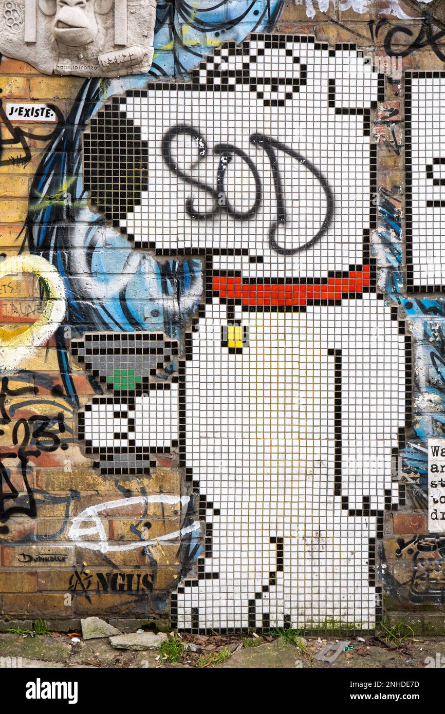 Street art. Defaced Brian Griffin mosaic on yellow brick wall in Camden Town district of London, England. Stock Photo