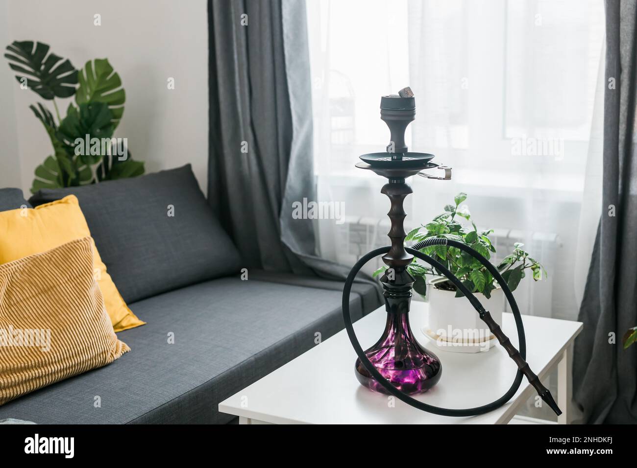 Hookah shisha with glass flask and metal bowl in room background