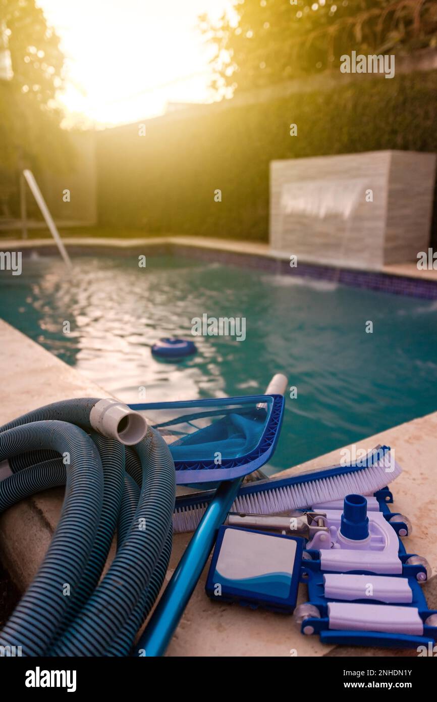 Pool cleaning and maintenance kit, Cleaning and maintenance tools on the edge of the pool. vacuum cleaner, ph test, skimmer and pool sweeper Stock Photo